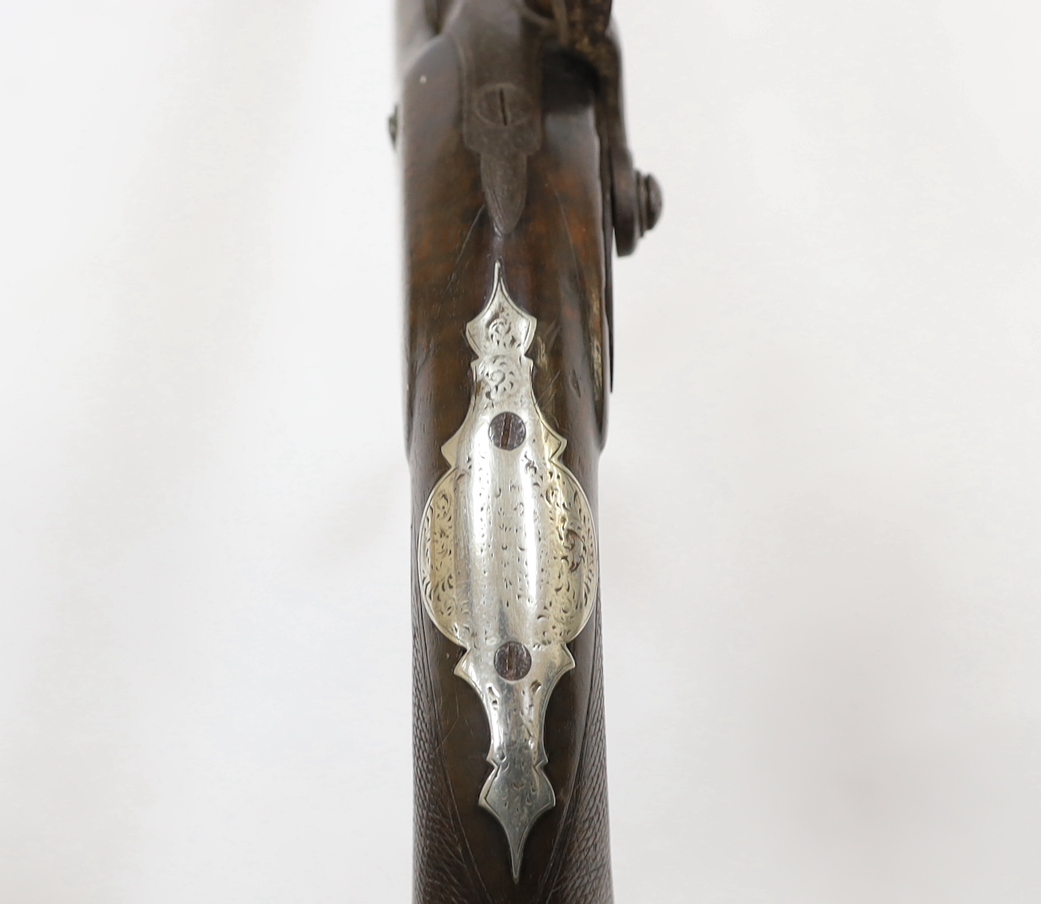A 22 bore percussion holster pistol probably made for the Indian market, octagonal barrel with nickel sight, chequered walnut stock, engraved nickel furniture with grotesque mask butt cap